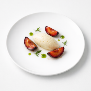 Präzise angerichtetes Dessert mit Zwetschgen, hellem Estragon-Sabayon und grünem Verbenenöl auf weißem Teller