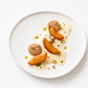 Gerösteter Pfirsich mit heller Vanille-Beurre-blanc, Haselnuss-Dacquoise und grünen Tropfen Zitronenthymianöl auf weißem Teller.